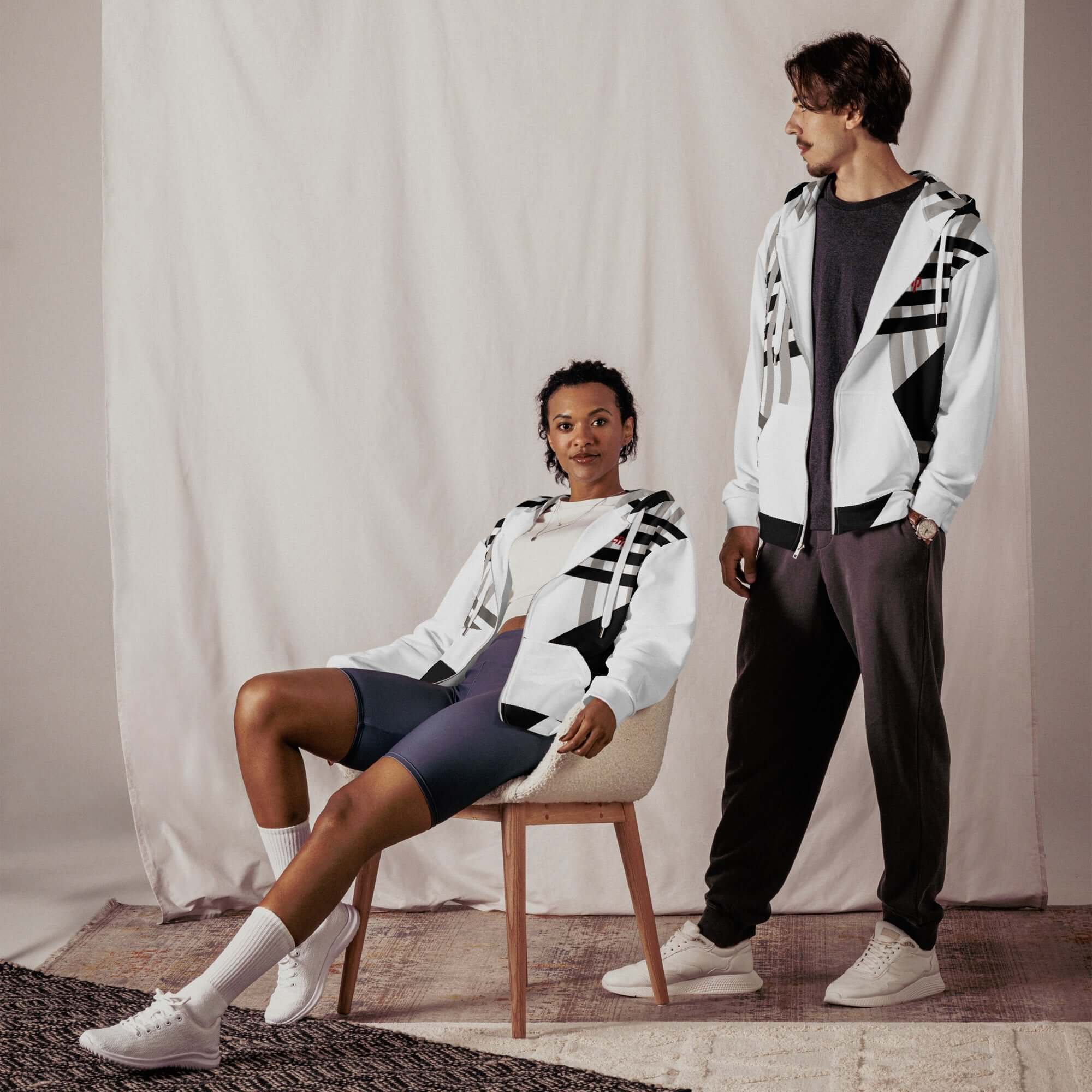 Trendy couple wearing stylish clothing and accessories, featuring hoodies and athletic wear for a modern look.